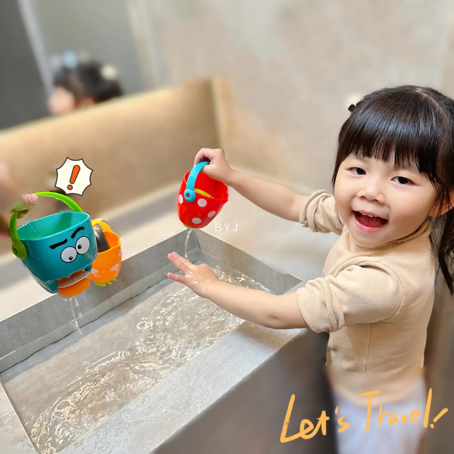 Rote, gepunktete Kunststoff-Gießkanne in Erdbeerform mit blauem Griff für das Spielset für Baby-Badewannen-Eimer mit Wassersprühfunktion.