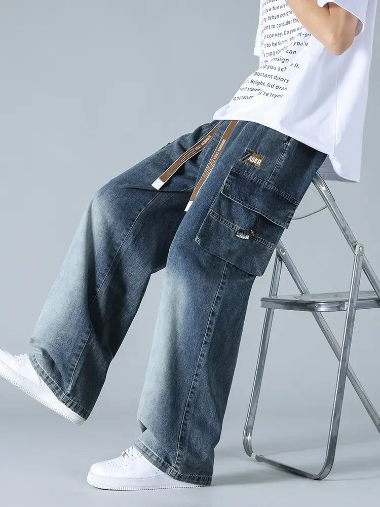 Jean cargo en denim ample pour homme, grande taille, teinte foncée, avec plusieurs poches et détail de boucle de ceinture marron.