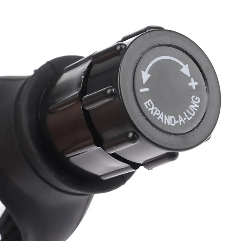 Black plastic lung capacity training device with a circular dial labeled expand-a-lung featuring directional arrows and plus and minus symbols used for respiratory fitness.