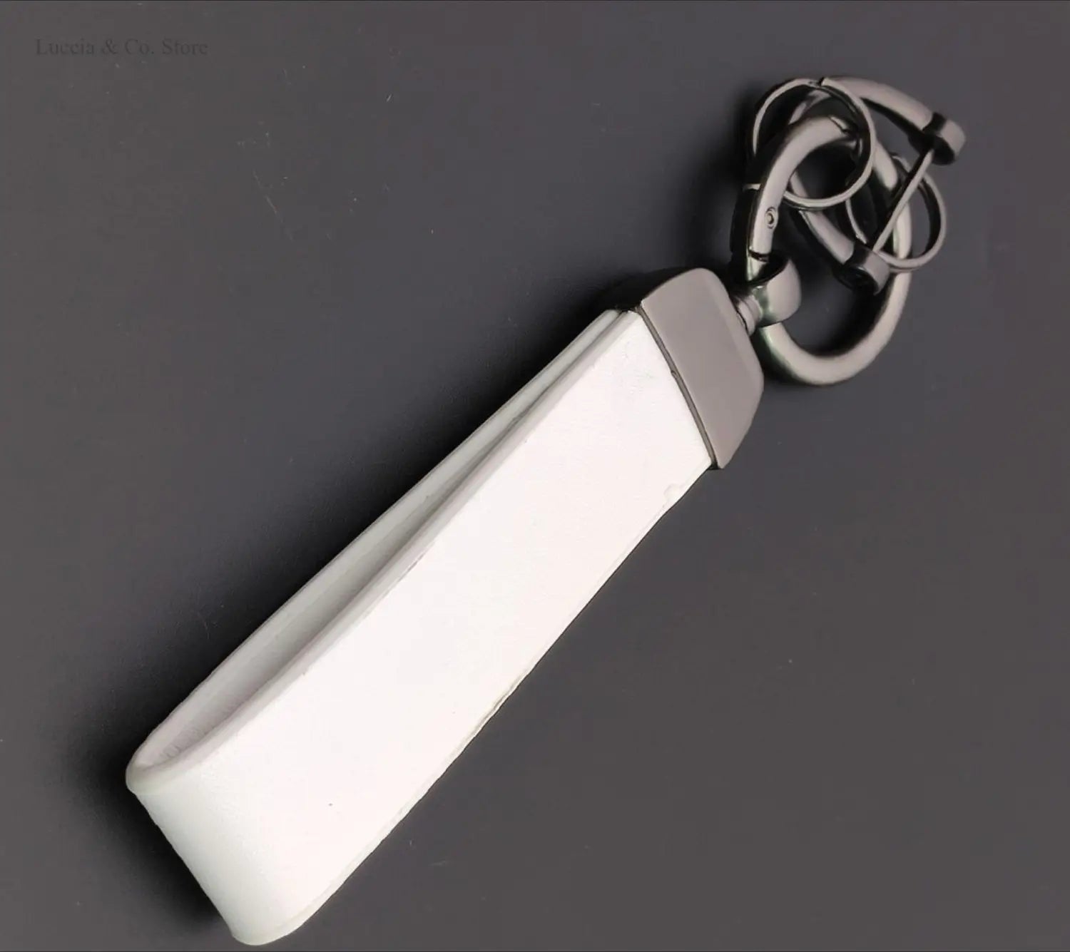 White rectangular custom logo car keychain with a sleek minimalist design and metallic silver hardware combines metal and leather materials for personalized use.