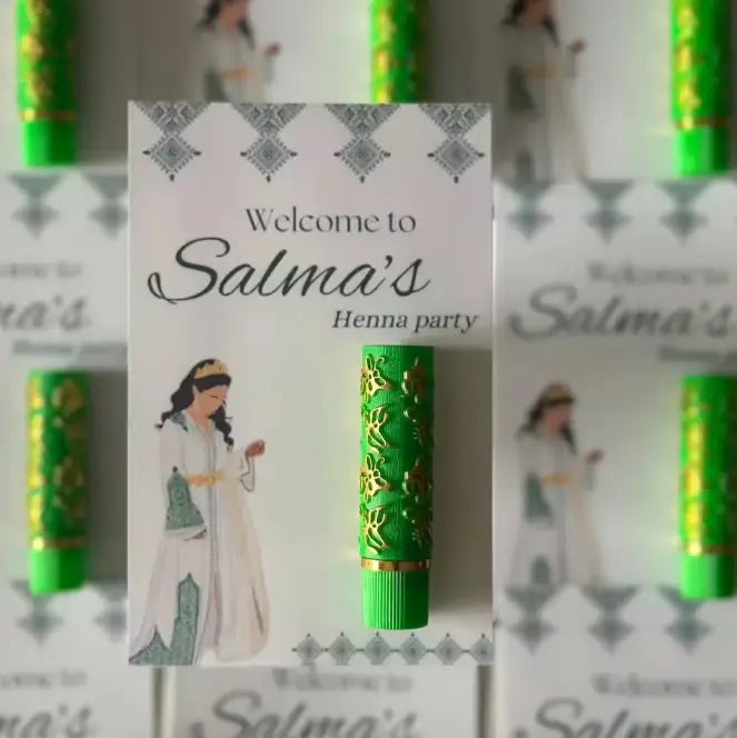 緑のヘナスティックに金色の花柄が施され、金属製のキャップを備えたカスタムの結婚式用香水プチギフトボトルであり、パーソナライズされたギフトカードのアクセサリーとして設計されています。