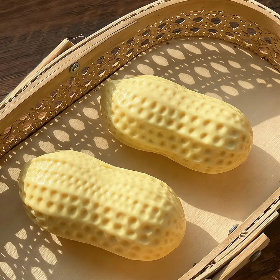 Two pale yellow textured soap ball stress relief peanut fidget toys rest in a woven bamboo tray highlighting the sealing area design.