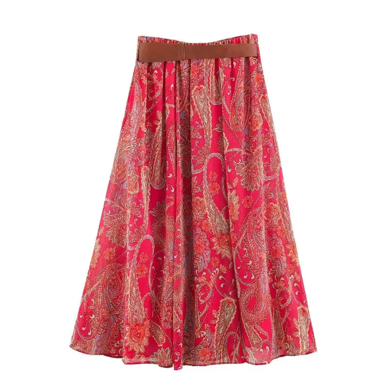 A flowing red paisley-patterned midi skirt with a brown belt from the red paisley halter top and midi skirt set.