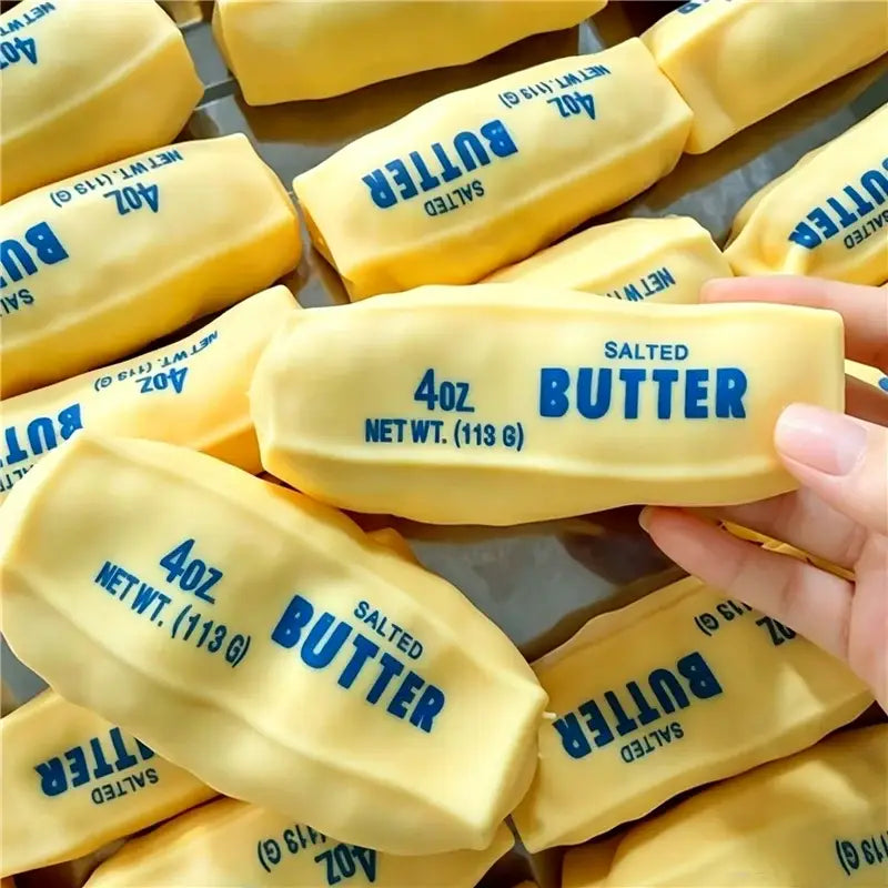Gelber gesalzener Butterstick als ASMR-Sensory-Squishy-Spielzeug mit einem 4oz-Butter-Aufkleber in blauem Text auf jedem gelben Stück