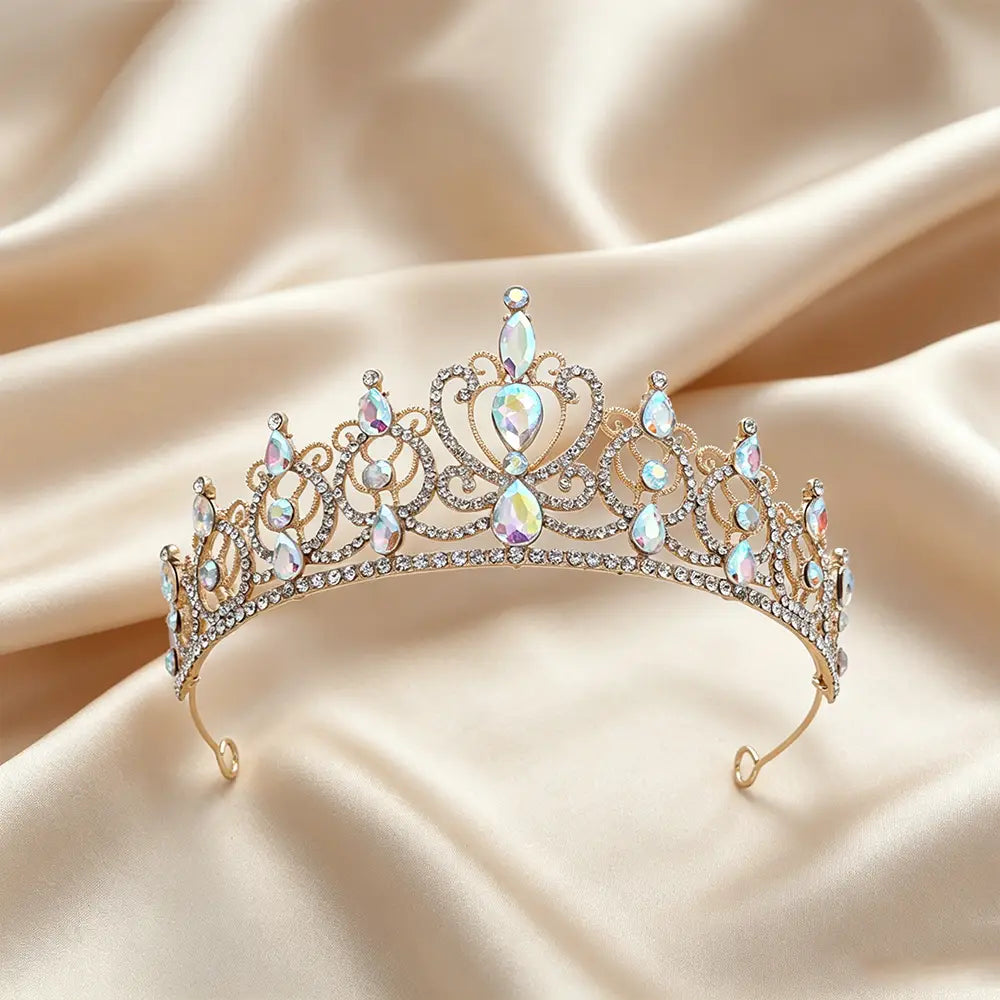 Un accessoire de coiffure de mariée en couronne de diadème baroque en strass doré, avec métal à tons dorés et cristaux transparents étincelants, irisés, en forme de goutte, dans un design royal et ornemental.