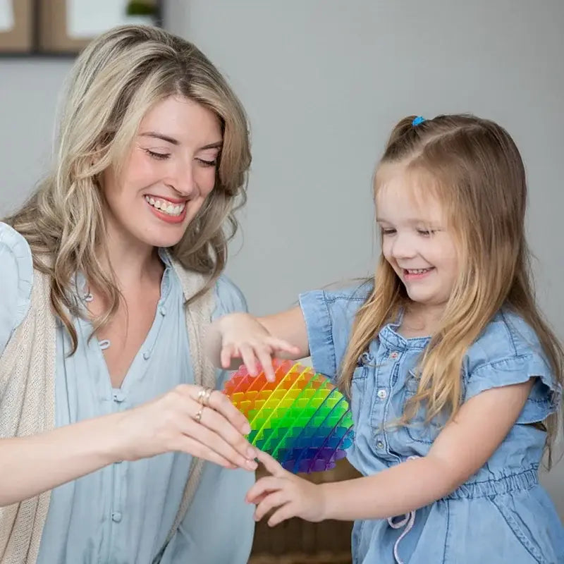 Regenbogenfarbenes Herz-förmiges elastisches Netz-Sinnes-Fidget-Wurmspielzeug mit einem Raster aus eindrückbaren Pop-it-Bläschen zur Stresslinderung und zur Förderung der Konzentration.