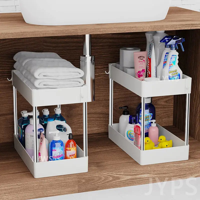 Rangement coulissant sous évier à deux niveaux de couleur blanche, avec cadre métallique argenté, conçu comme organisateur d’évier et rangement de placard pour la cuisine et la salle de bain.