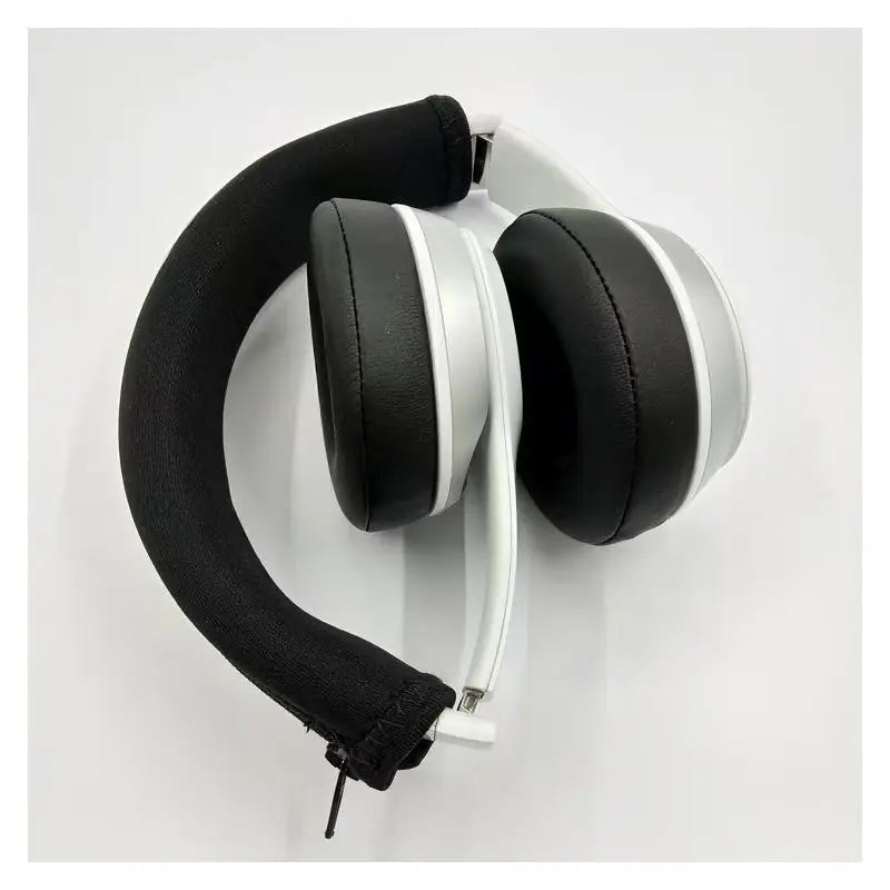 Black and silver over-ear headphones with padded earcups and a fabric-covered neoprene zipper cushion headband cover.