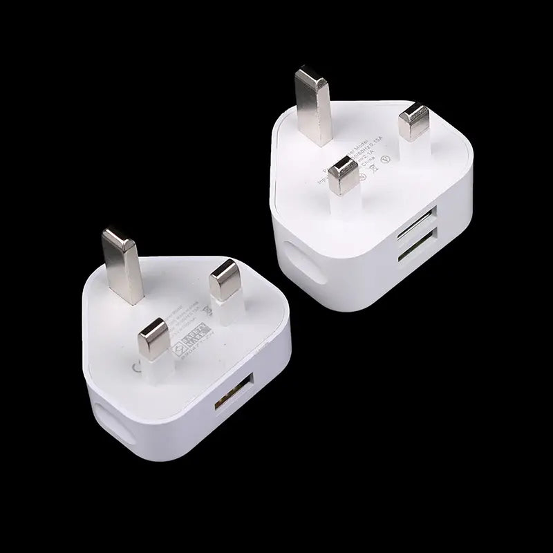 Adaptador de cargador de pared doble USB de 3 clavijas tipo Reino Unido en plástico blanco con clavijas metálicas y dos puertos USB, mostrado desde la parte posterior.