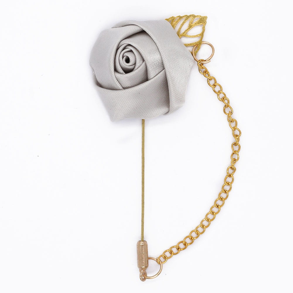 Boutonnière de rose bordeaux comportant une délicate épingle en rose en satin argenté, avec une chaîne à tons dorés et un accent feuillu.