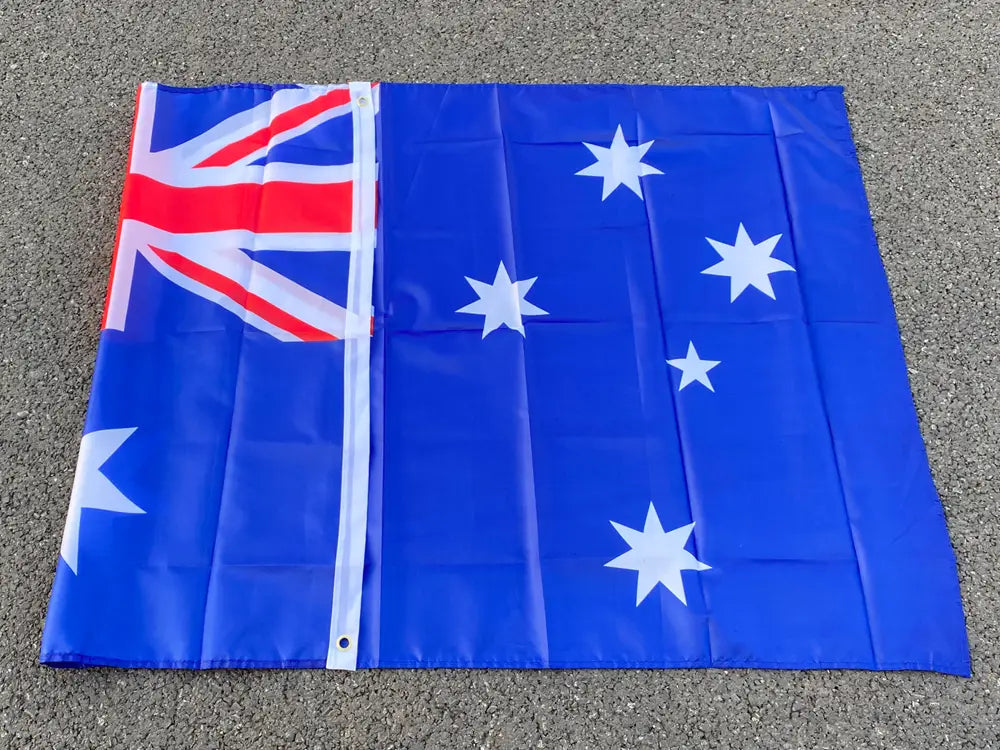 Bandera nacional australiana de 90x150 cm, en azul, con estrellas blancas y un aspa de la bandera británica roja, blanca y azul en la esquina, mostrada plana.