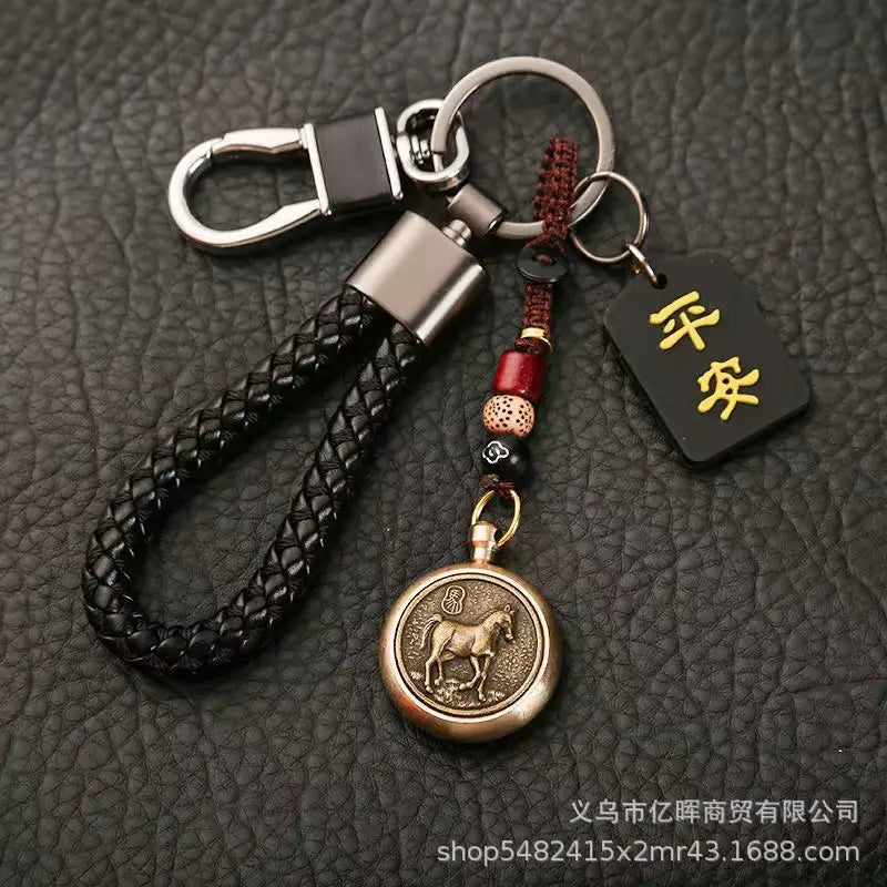 中国の干支ラッキーペンダントとして。ブロンズの「馬」メダリオンと赤いビーズのアクセントを備えた黒の編みレザー製キーチェーン。