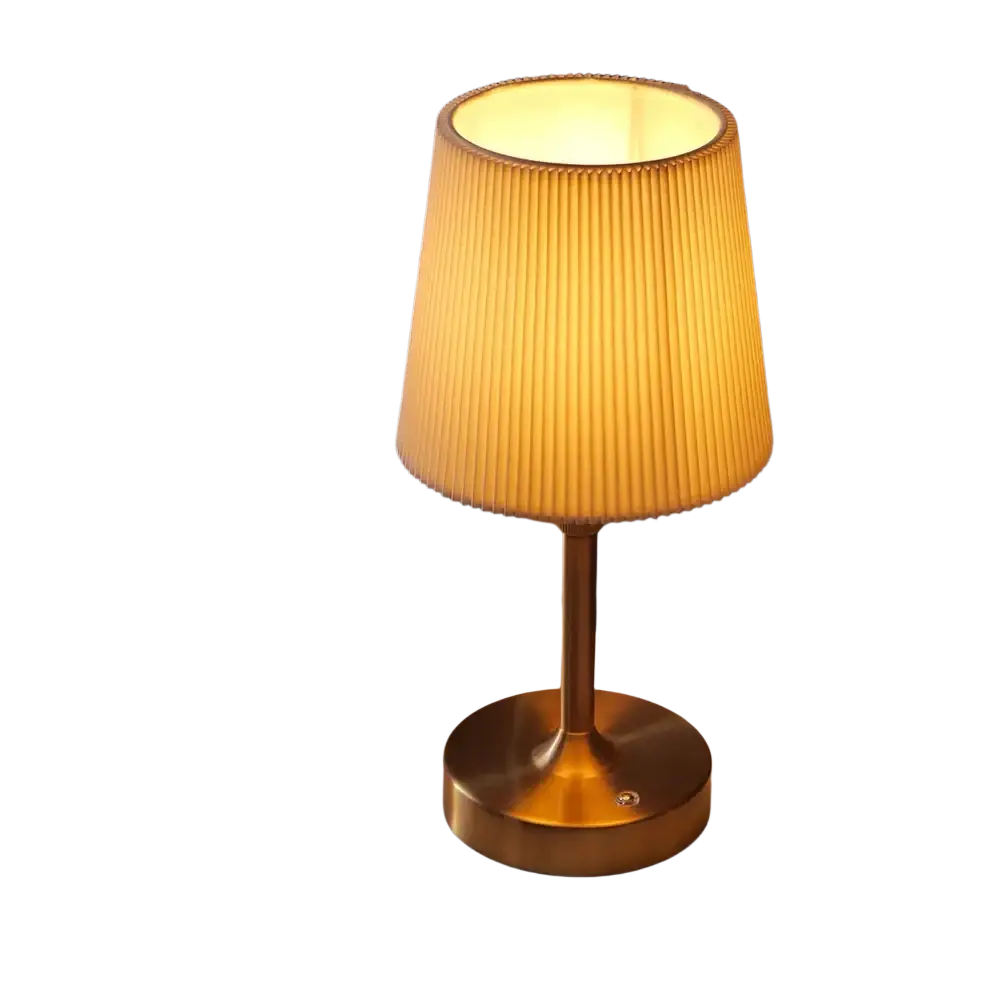 Led fabric book light with warm-toned pleated lampshade on brass-finished base for ambient lighting in bedrooms