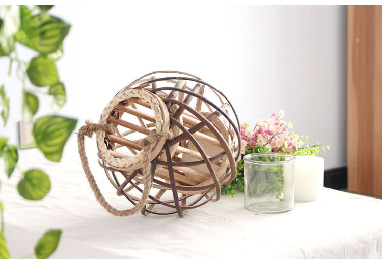 Un porte-bougie rustique en bambou tissé, avec un cadre en bois naturel et une poignée épaisse en corde de jute, conçu pour la décoration intérieure du domicile.
