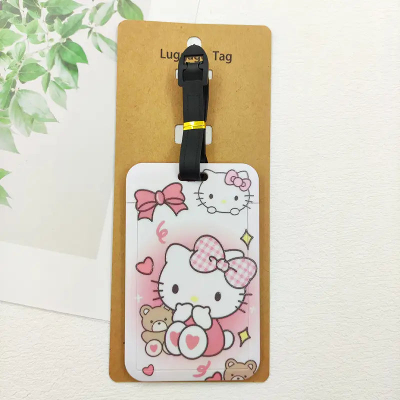 Ensemble d’étiquettes de bagage Hello Kitty comportant un design de dessin animé rose et blanc, une sangle noire et un accent doré pour l’identification de la valise.