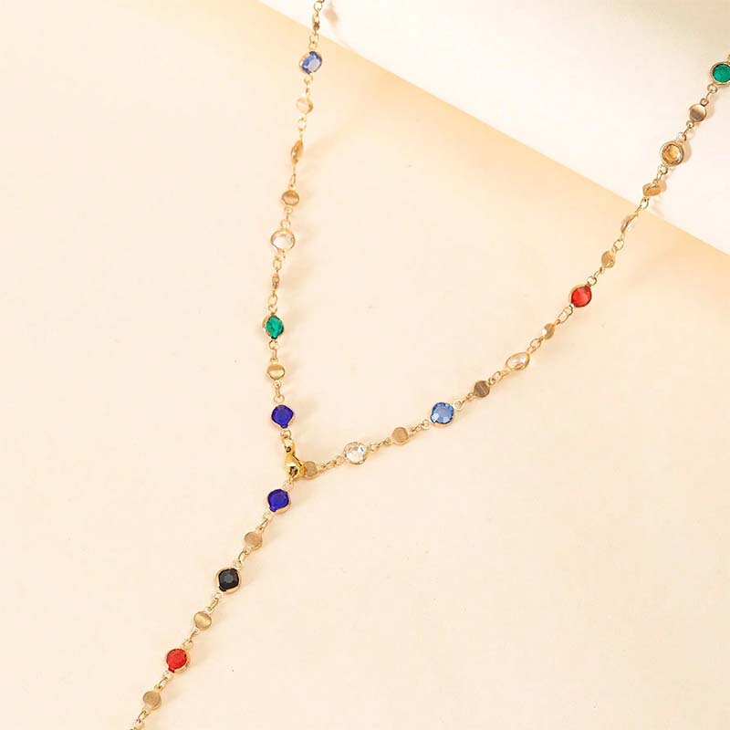 Eine zarte Halskette im Y-Design in Goldton, verziert mit farbenfrohen facettierten Kristallen in Rot, Blau, Grün und Klar, genannt farbenfrohe Kristallquasten-Halskette als Statement.