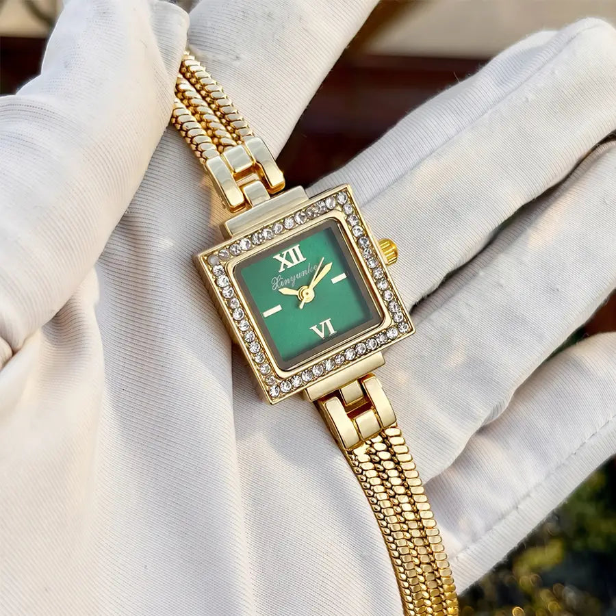 Gold diamond square watch featuring a gold-toned case with a green dial, roman numerals, and a diamond-encrusted bezel paired with a vintage fringe strap.