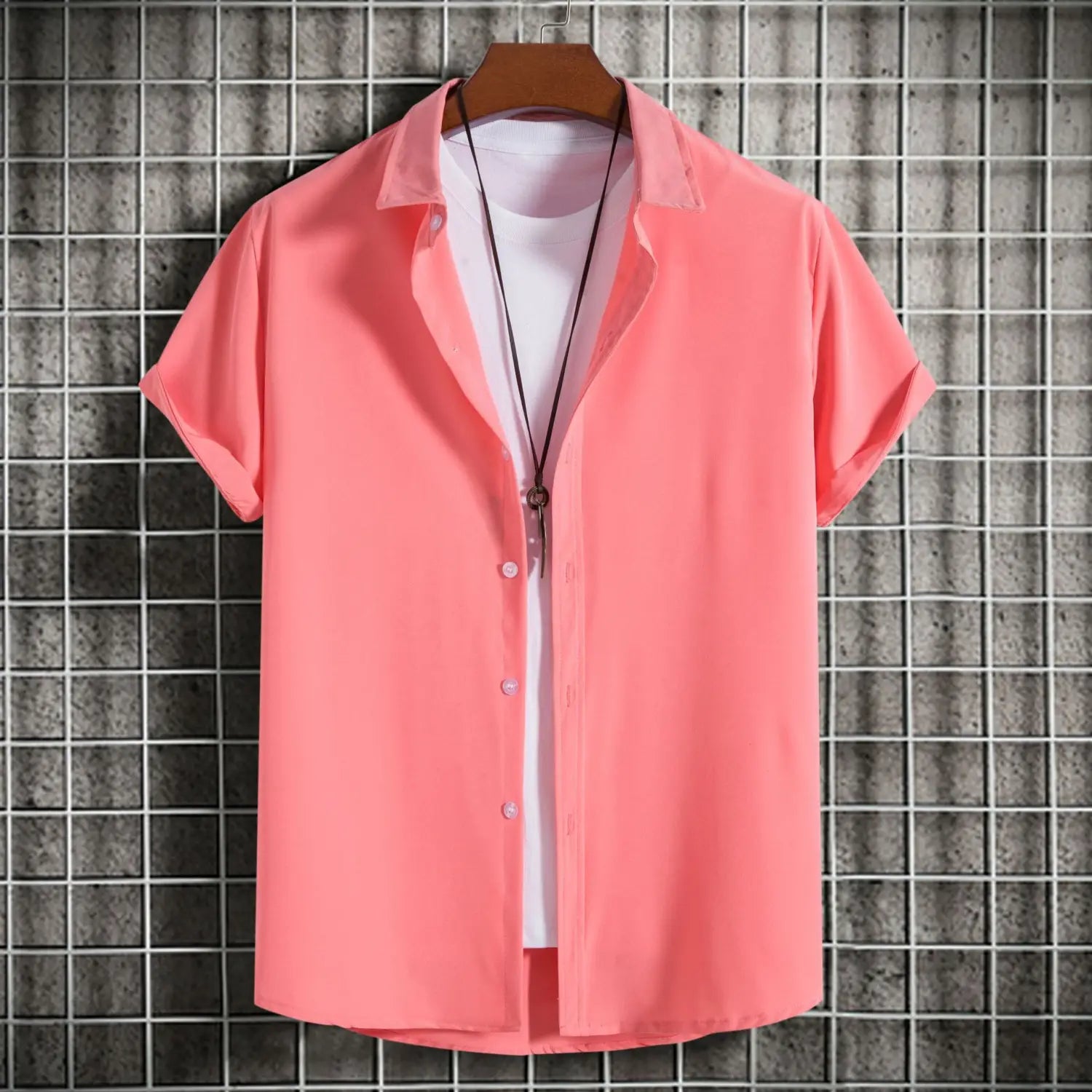 chemise à manches courtes de couleur corail pour homme, avec col et boutons, présentée sur un cintre en bois, idéale pour des vêtements décontractés et des styles unis pour hommes.
