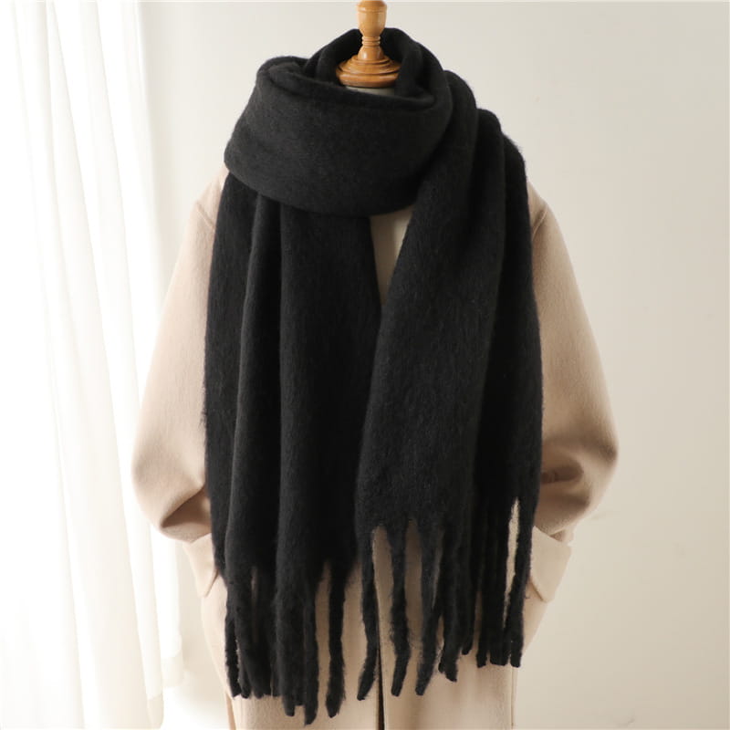 Ein flauschiger schwarzer Strick-Schal für Damen mit Cashmere-ähnlichem Gefühl für den Winter mit weicher, samtig-flauschiger Textur und langen gefransten Enden.