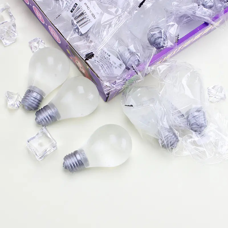 Bombillas de luz de vidrio esmerilado transparente con bases metálicas en rosca, diseñadas como juguetes antiestrés tipo gomita con forma de bombilla.