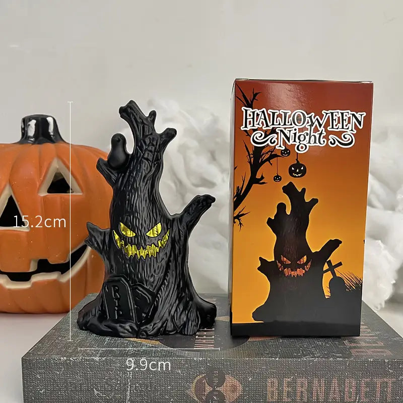 Led Halloween ghost tree light spooky decoration featuring a black resin figurine of a spooky tree with glowing yellow eyes and teeth.