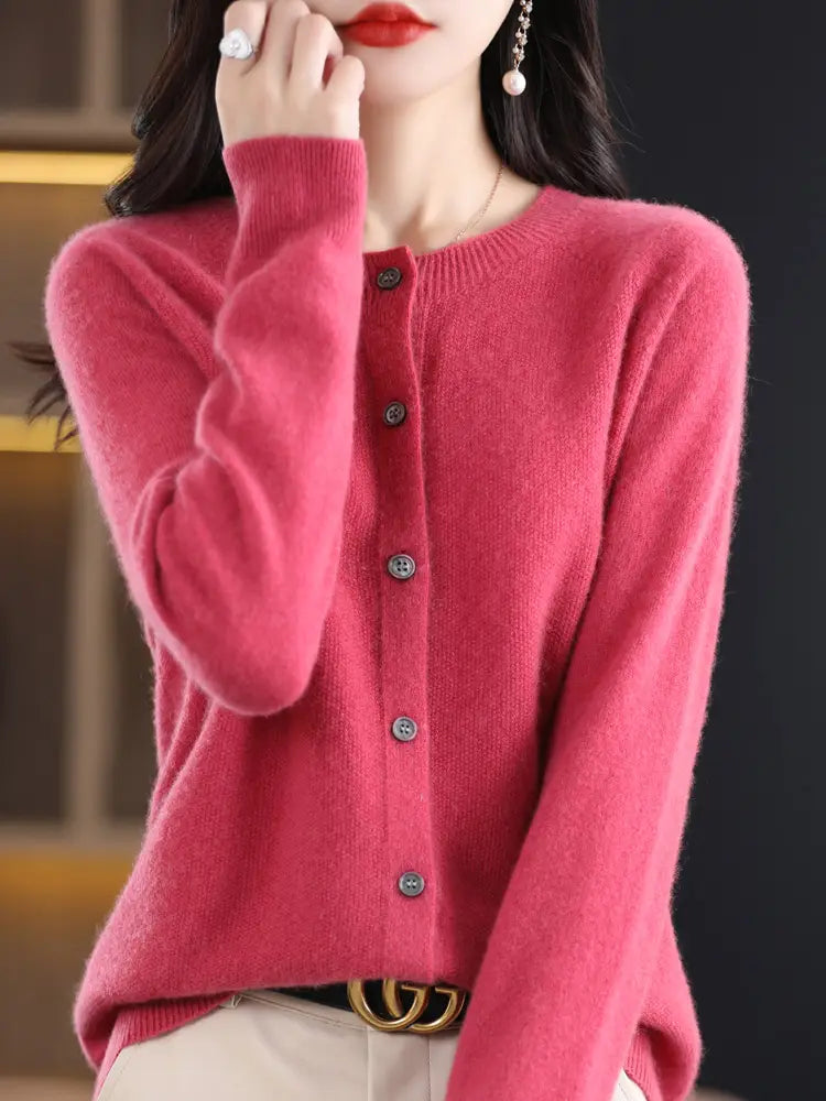 A soft vibrant pink merino wool cardigan for women with a round neckline and five dark gray buttons down the front.