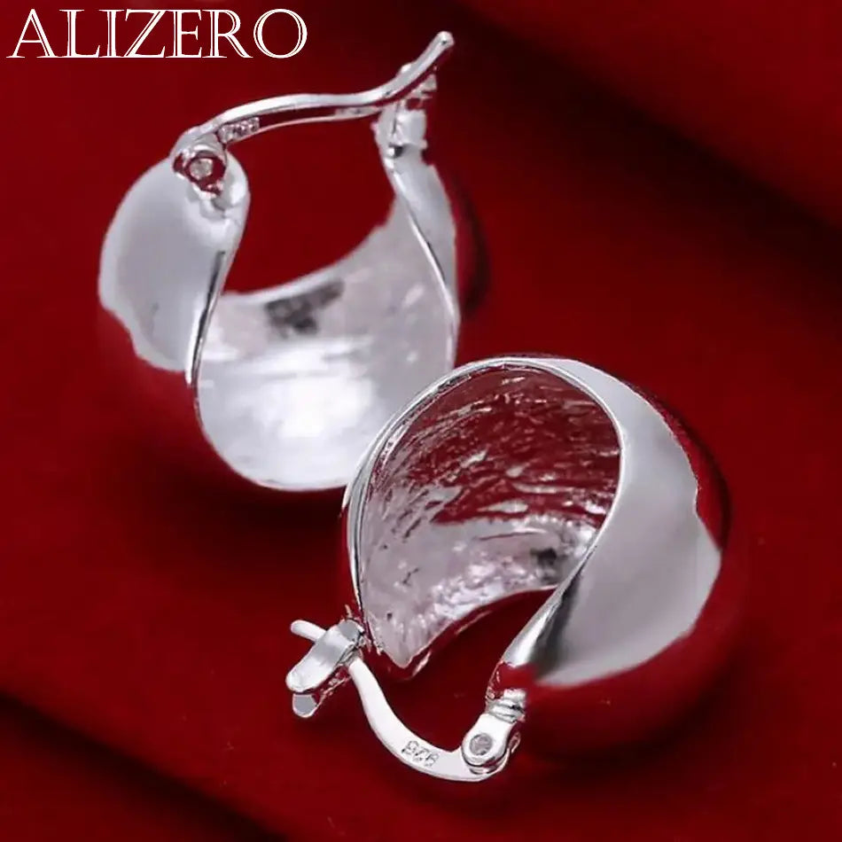 Boucles d’oreilles créoles minimalistes en argent sterling 925, avec une surface texturée polie et un design moderne et épuré.