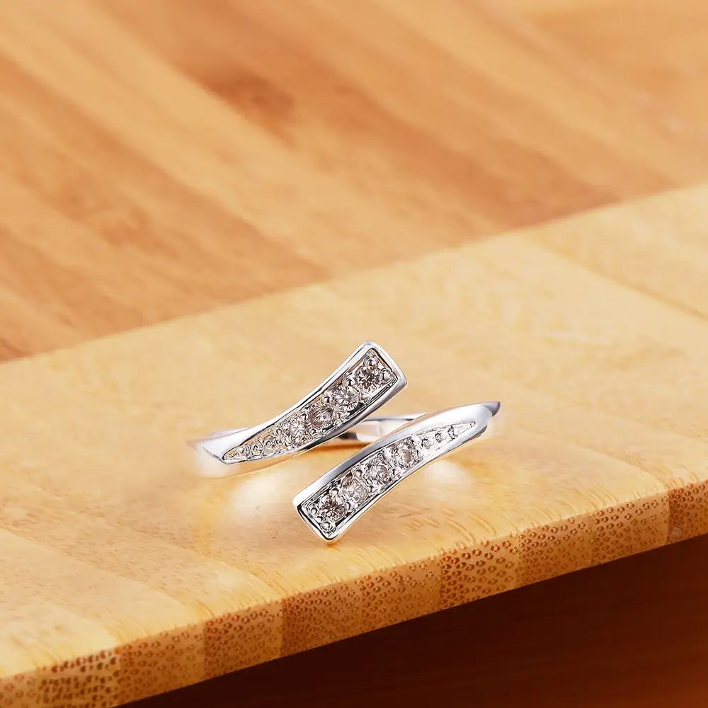 Offener Silberring mit einem geschwungenen rechteckigen Band, besetzt mit klaren kubischen Zirkonia-Steinen, gestaltet als verstellbarer Zirkonring aus 18k Gold für Damen.