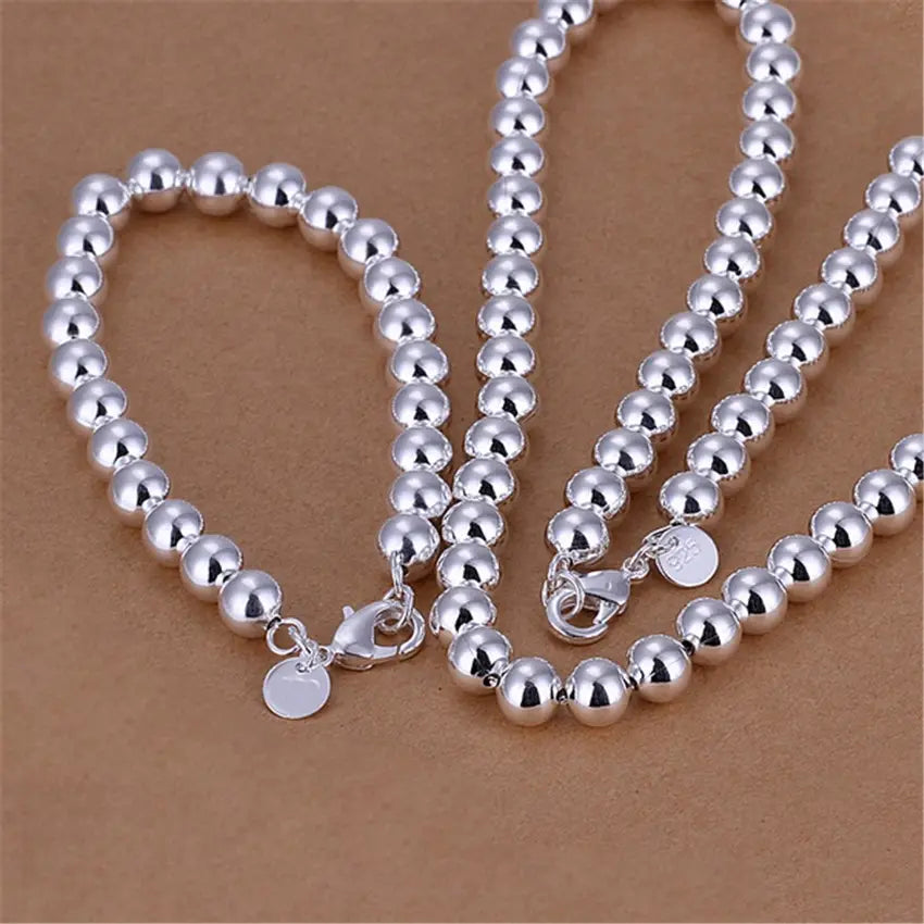 Ensemble de parure en argent vieilli orné de perles : collier et bracelet en argent sterling, perles sphériques polies, fermetures à déclic solidement fixées et petites étiquettes rondes.