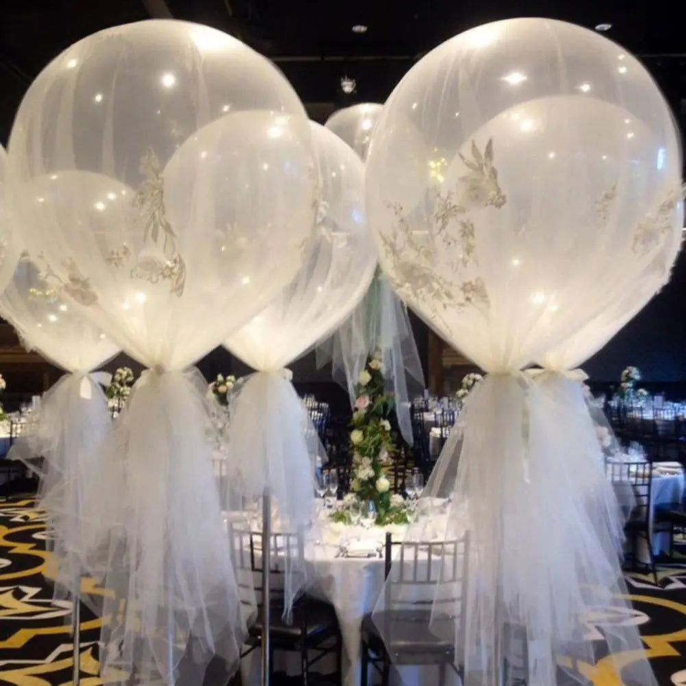 Décoration de ballon de mariage de 36 pouces pour fête romantique comprenant de grands ballons transparents avec une délicate broderie florale dorée et des rubans en tulle blanc, qui s’écoulent.