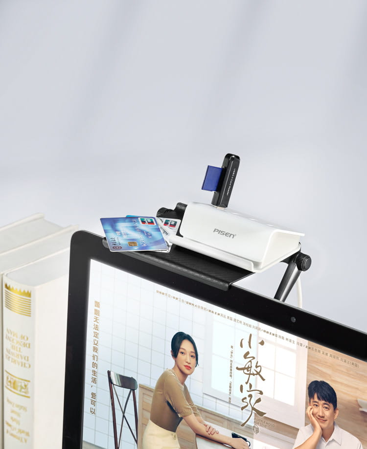 white pisen document scanner with black adjustable arm and blue card slot positioned on a desk next to an open laptop on an adjustable screen top storage shelf monitor stand.