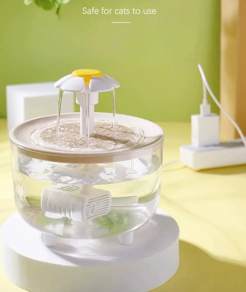 White and yellow cat water fountain with a flower-shaped top, clear glass tiers, and an internal pump for use as a usb water dispenser.