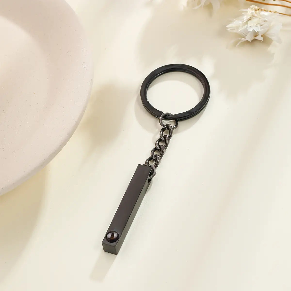 Black matte-finished metal custom photo projection keychain with a rectangular pendant and chain personalized as a memorial gift.