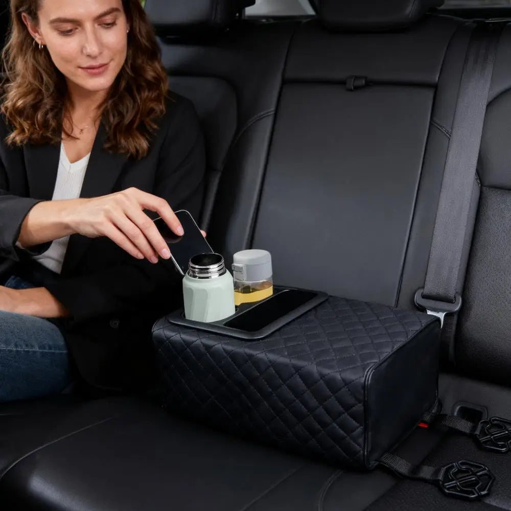 Organizador negro acolchado de cuero para consola de automóvil con espuma viscoelástica, que incorpora un soporte para el teléfono y ranuras para portavasos para uso en el vehículo