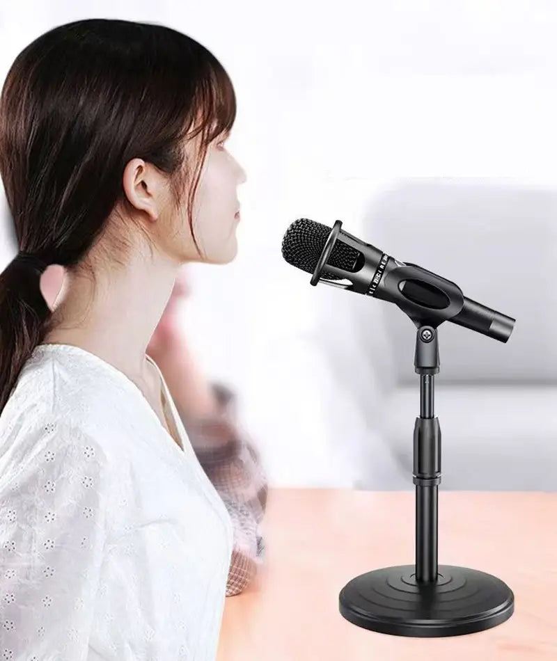 black handheld microphone mounted on an adjustable desktop metal microphone stand and holder
