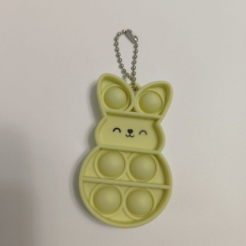 a pale yellow rabbit pop it fidget keychain featuring a bunny shape and a silver chain keyring