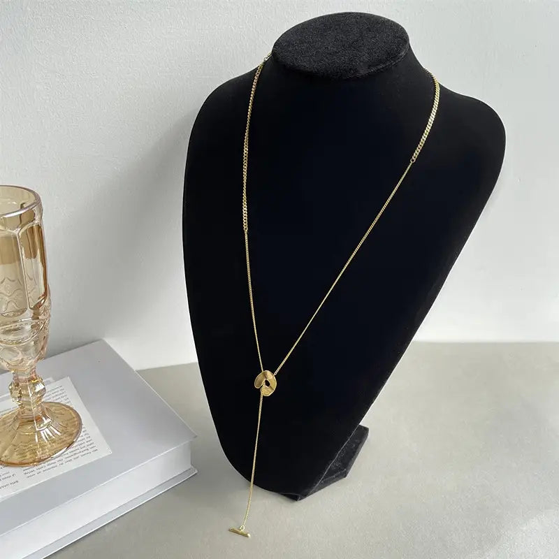 Collier en chaîne aux tons dorés avec un pendentif central circulaire et un accent t-bar pendant, dans un collier pendentif à superposition géométrique doré pour femmes.