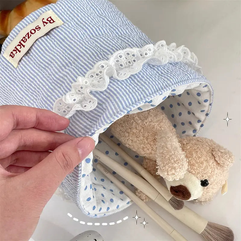 Gepolsterter Aufbewahrungskorb mit weichem blau-weiß gestreiftem Stoff, feinem Spitzenbesatz und einem innenliegenden Polka-Dot-Futter