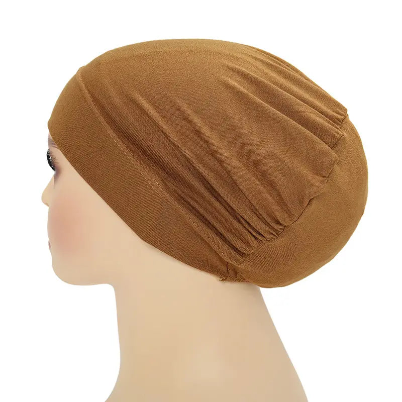 A soft tan-colored stretchy jersey fabric hijab cap and turban set with a gathered pleated design.