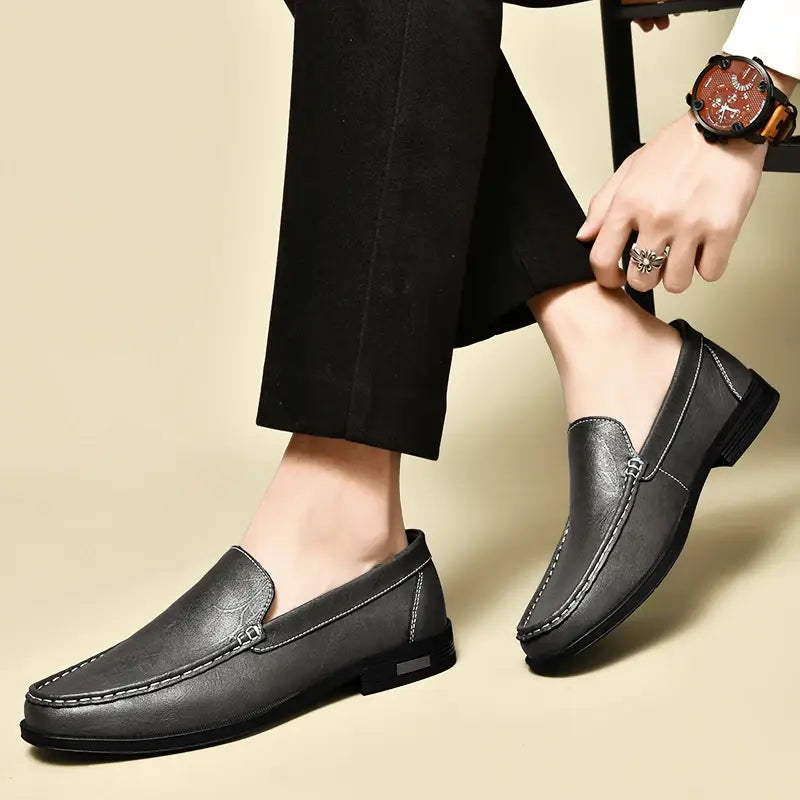 Men genuine leather slip-on dress loafers in black featuring contrasting white stitching and a low-profile sole.