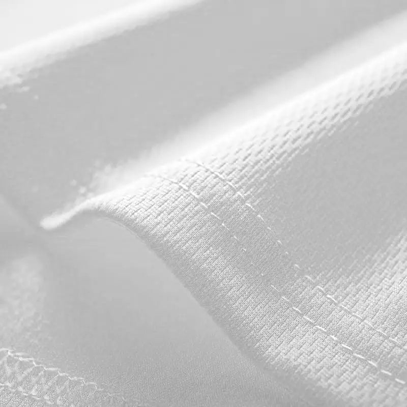 Tissu blanc tissé à séchage rapide avec un motif texturé subtil et une couture soignée le long du bord d’un débardeur de sport pour homme conçu pour accomplir la tâche, gilet de fitness.