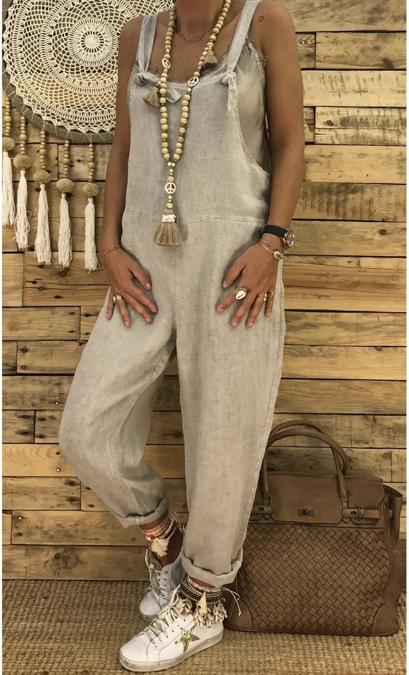 Hell ausgewaschene Jeans-Latzhosen für Damen mit verstellbaren Trägern und einer entspannten, zulaufenden Passform, entworfen für das Tragen im Sommer.