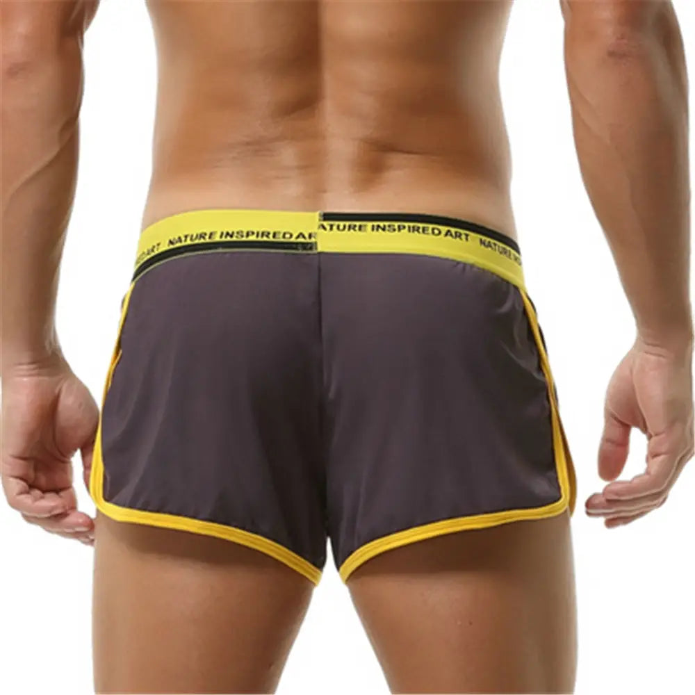 Boxer briefs para hombre transpirables, atléticos y de dormir, de color gris oscuro, con ribetes amarillo intenso y una pretina que presenta un texto con arte inspirado en la naturaleza en la banda elástica.