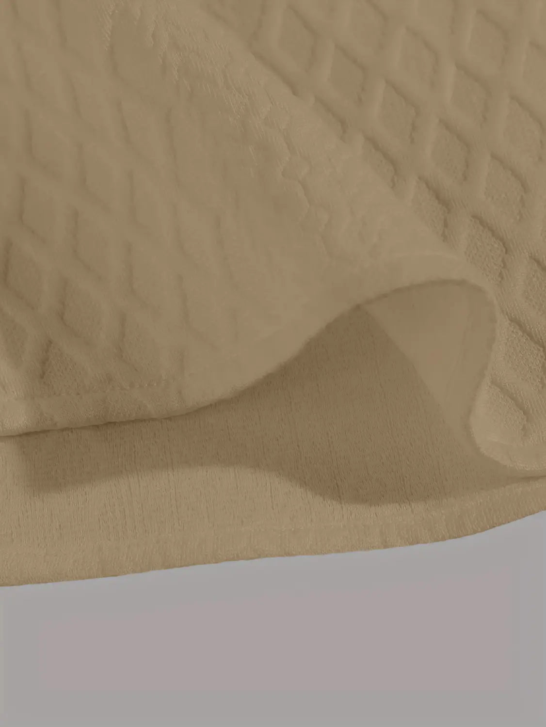 tissu beige matelassé avec un motif losange présenté sur le haut gris en maille diamant à manches courtes.