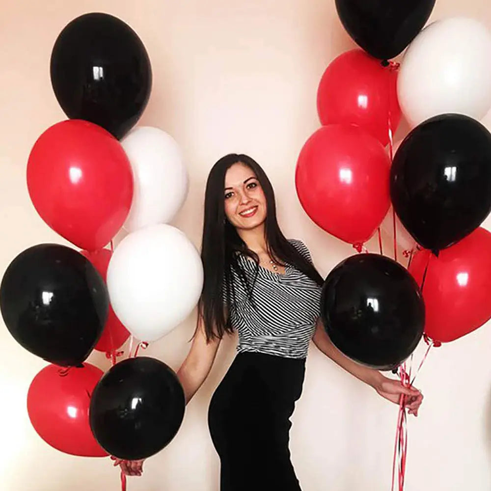 Eine Frau in einem Oberteil mit schwarzem und weißem Streifen hält Ballon-Cluster aus glänzendem rotem, schwarzem und weißem Latexluftballon, aus dem roten schwarzen weißen Ballon-Set für die Partydekoration.