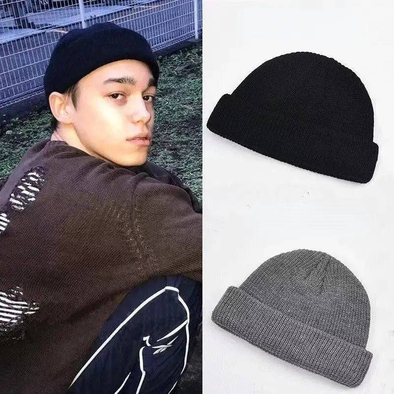 Black ribbed knit winter beanie hat with a folded brim made of warm knitted material for unisex use.