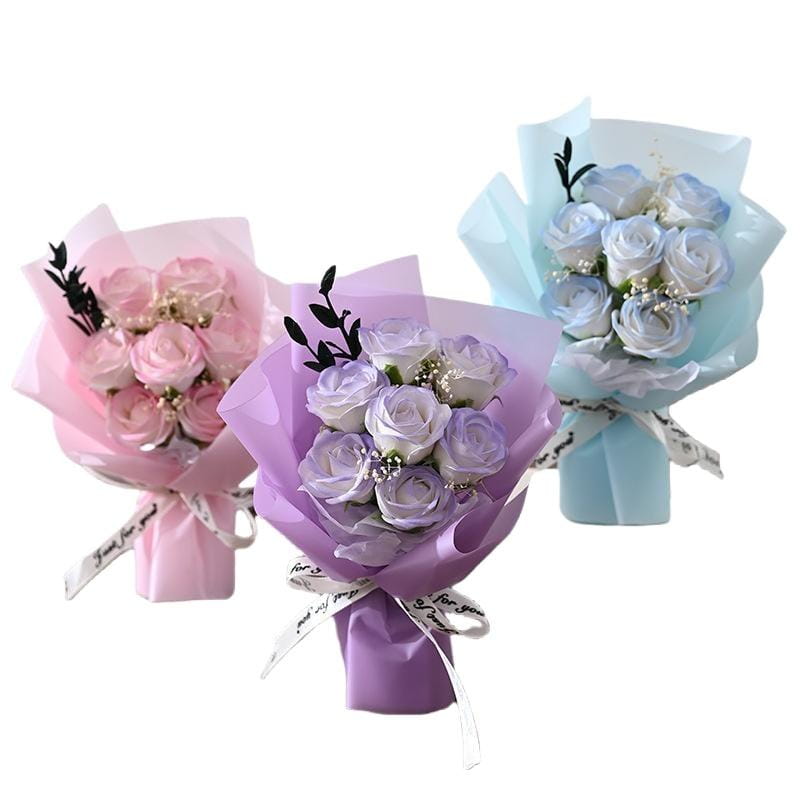 Three delicate pastel-colored artificial rose flower bouquets wrapped in matching tissue paper and tied with ribbon, ideal for gifts.