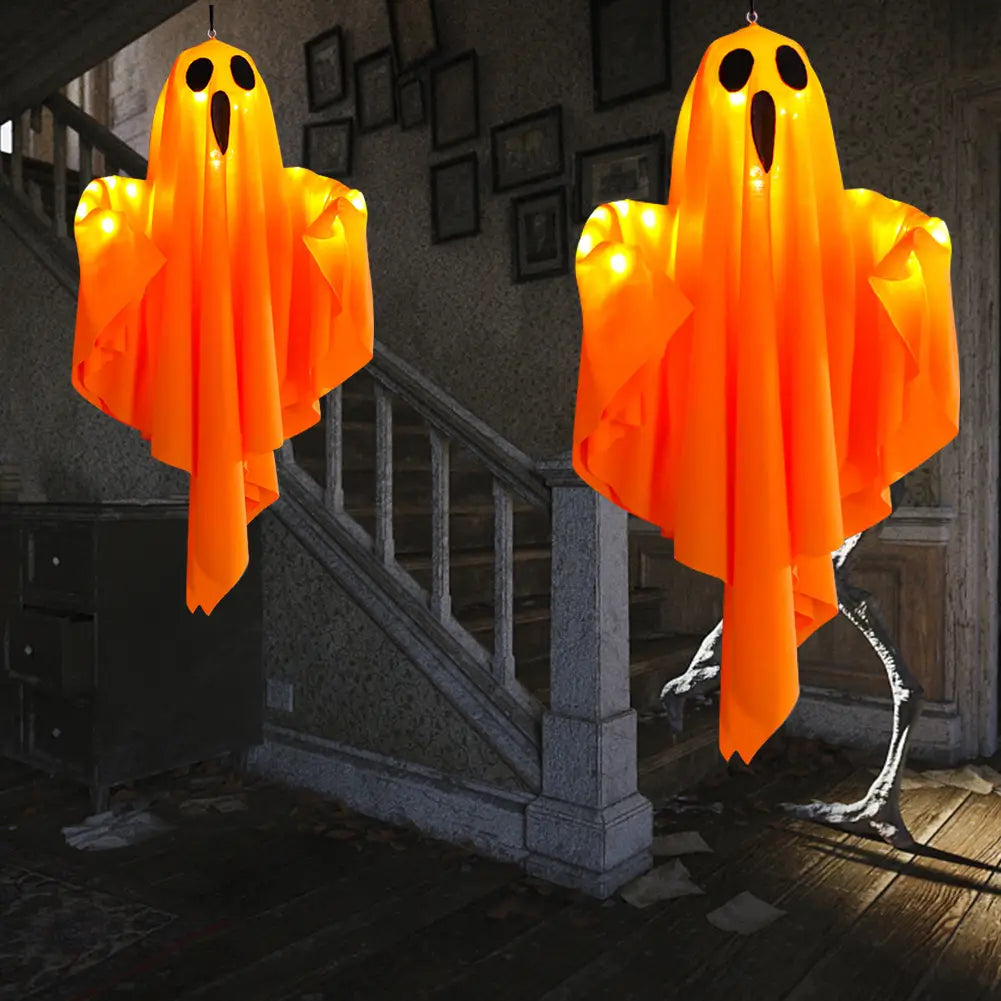 two glowing orange led hanging ghost halloween decorations made of lightweight fabric with black eye and mouth cutouts