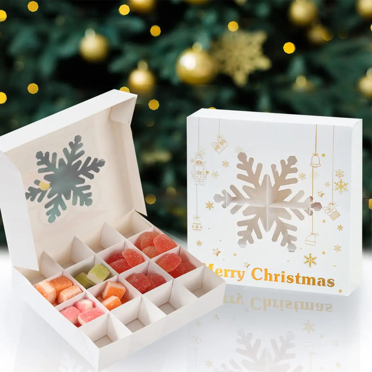 white christmas gift box with gold foil accents and snowflake design containing colorful gummy candies in individual compartments for paper treat packaging of cookies