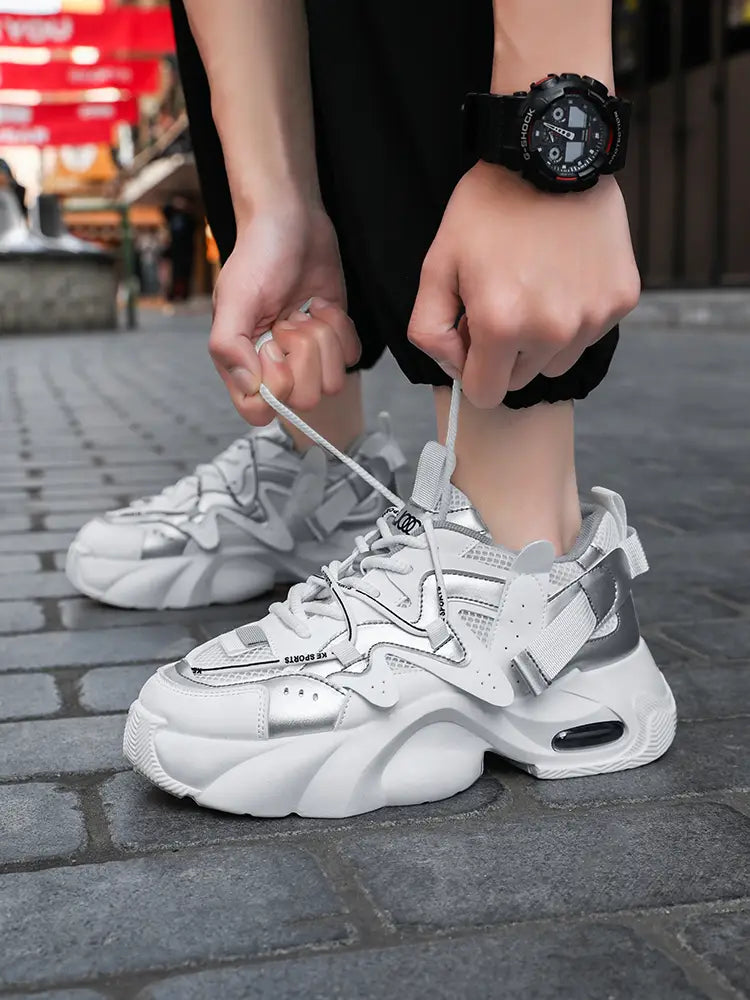 Men chunky air cushion casual sneakers in white and silver with a bold layered design featuring mesh panels and thick rubber soles.